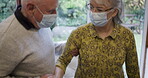 Covid, help and support by senior couple in retirement home or house with disabled woman due to old age. Elderly, mask and people helping to walk and holding with care by caregiver or husband