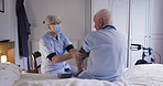 Homecare, consultation and nurse with a senior man checking his blood pressure in his bedroom. Healthcare, medical and female caregiver with a face mask consulting elderly patient at retirement home.