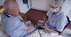 Healthcare, blood pressure or exam with a woman nurse and a man patient in a retirement home bedroom. Medical, exam and assisted living with a senior male sitting on his house bed from above