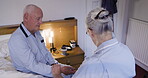 Senior man, rehab and checkup with caregiver taking pulse, blood pressure or sugar level. Elderly male in support, visit or diabetic at home with woman nurse monitoring health or wellness in bedroom