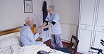 Healthcare, old man and caregiver with pills, bedroom and recovery in nursing home, assistance and rehabilitation. Male senior citizen, female nurse and mature woman with medicine, medical and help