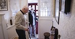 Carer, covid and senior man opening door for healthcare, elderly care and home help. Retirement, work and patient welcoming a house nurse for helping, rehabilitation and nursing consultation