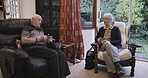 Coffee, talking and love with a senior couple sitting in the living room of their retirement home together. Tea, conversation or bonding with a mature man and woman chatting in the lounge of a house