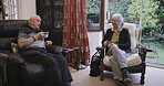 Tea, conversation and love with a senior couple sitting in the living room of their retirement home together. Coffee, talking or bonding with a mature man and woman chatting in the lounge of a house