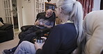 Tea, chatting and love with a senior couple sitting in the living room of their retirement home together. Coffee, conversation or bonding with a mature man and woman talking in the lounge of a house