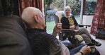 Coffee, conversation and love with a senior couple sitting in the living room of their retirement home together. Tea, talking or bonding with a mature man and woman chatting in the lounge of a house