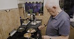 Food, senior and man cooking dinner, lunch or breakfast on the stove in the kitchen. Chef, retirement and a hungry elderly person in the process of making a meal in the morning for eating at home