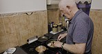 Senior man, cooking and home kitchen stove while preparing breakfast, brunch or lunch in a pan. Old man making food with nutrition in morning for health and wellness for retirement lifestyle