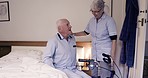 Bedroom, wheelchair and nurse with senior man for healthcare, disability assistance and medical support. Nursing home, retirement and caregiver helping sick, disabled and elderly patient from bed