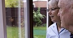 Window, old man and nurse, talking and smile with healthcare, house and discuss memories. Glass, male senior citizen with caregiver and happy woman in nursing home, conversation and support in lounge