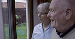 Elderly, couple and talking with retirement and relax at home, looking out the window with communication. Happiness, marriage and life partner, health and old people have conversation about view