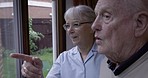 Conversation, senior and couple with a window view in the morning during retirement in home. Happy, discussion and elderly man and woman looking at a garden from a house for enjoyment and relaxation