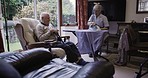 Senior couple, home rehabilitation and communication in lounge doing ironing, cleaning and happy bonding. Old man and woman cleaner, caregiver or nurse in house for laundry and talking retirement