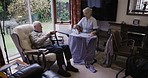 Senior couple, retirement home and communication in living room while doing ironing, cleaning and happy bonding. Old man and woman cleaner, caregiver or nurse for laundry, rehabilitation and talking
