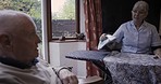 Senior couple, home and communication while ironing in living room for cleaning and happy bonding. Old man and woman cleaner, caregiver or nurse in house for clean laundry and support in retirement