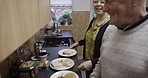Real people, kitchen and couple with dinner, lunch or a meal together in their home in London. Cooking, happy and senior man and woman in retirement preparing to eat supper or food in a town house.