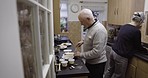 Mature couple, cooking together in retirement and food with lifestyle, wellness and nutrition with healthy meal. Help, love and care in marriage, old man and woman in kitchen, trust and retired