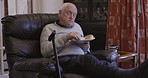 Retirement, senior and man eating and relax sitting on a couch or sofa resting, break and enjoying a snack or food. Elderly, pensioner and old person is retired holding a plate in a house