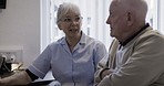 Computer, discussion and woman helping a man with online technology in his retirement home. Tech, internet and senior female talking and assisting a elderly guy with a pc for networking at his house.