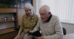 Senior couple, smartphone and talking in home on social media, internet and online news app. Old people, cellphone and connect in living room, house and relax with mobile technology, network and text