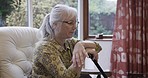 Retirement, depression and senior woman in nursing home with memories, nostalgia and thoughtful. Thinking, mental health and sad, lonely and elderly lady in living room for sitting by window for calm