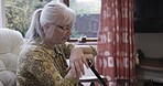 Retirement, thinking and senior woman in chair by window with memories, nostalgia and thoughtful. Nursing home, depression and sad, lonely and elderly lady in living room for peace, quiet and calm