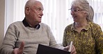 Photo album, senior couple and talking in a living room, happy and smile while enjoying a peaceful morning. Love, elderly and old man with woman for photo, book or memories while enjoying retirement 
