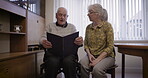 Photo album, relax and senior couple in home reading together, bonding and enjoying quality time. Love, memory and elderly retired man and woman study or read picture book for nostalgia in house.