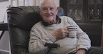 Sofa, coffee and senior man relax in living room, talking and enjoying conversation in his house. Elderly male, tea and speaking to a person while sitting on a couch, relaxing and chilling in lounge 
