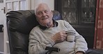 Coffee, sofa and senior man relax in living room, watching and enjoying a movie in his house. Elderly male, tea and enjoying television programme while sitting on couch, relaxing and chill in lounge 