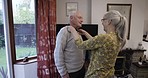 Elderly man, woman and help with dress up for clothes, homecare support and care in nursing home. Senior couple, helping hand and shirt collar in room to start morning together for happiness by house