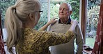 Elderly couple, woman and help with dress up for clothes, homecare support and care in nursing home. Senior couple, helping hand and shirt collar in room to with happy morning chat together in house