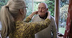 Caregiver help senior man dress in a retirement home and preparing clothes in a nursing house or room. Elderly, old and mature pensioner, retired or handicapped person gets assistance by nurse