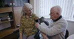 Health, blood pressure and an old couple together in their retirement home for a wellness checkup. Medical, cardiovascular and cholesterol with a senior man and woman testing for hypertension