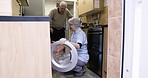 Helping, cleaning and senior couple doing laundry, loading clothes and housework in washing machine. Working, help and elderly man and woman talking and sorting clothing for chores and housekeeping