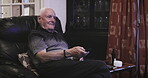 Senior man, sofa and smile watching tv with remote for changing channels, entertainment or movie at home. Elderly male in retirement streaming online shows relaxing in the living room on soft chair