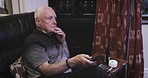 Senior man, sofa and watching tv with remote for changing channels, entertainment or movie at home. Elderly male in retirement streaming online show relaxing in the living room on soft couch or chair