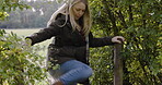 Woman, travel and walking over fence in forest for  nature adventure, trip or exploring the countryside. Female tourist, explorer or traveler taking walk in woods through obstacle for holiday weekend