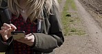 Nature, walk and woman scrolling on a phone for research on the internet or mobile app with 5g network. Technology, outdoor and lady browsing on social media with a cellphone while walking in a field