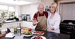 Kitchen, cooking and old man in teaching woman to make salad, love and happiness in retirement with healthy food. Happy senior couple, smile and apron, marriage bonding, helping with lunch in home.