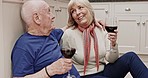 Kiss, toast and wine, old couple on floor in kitchen, love and cheers to celebrate happiness and retirement. Relax, marriage and elderly man with woman on ground in apartment with drinks and smile.