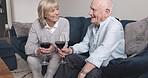 Love, alcohol and senior couple on a couch, talking and discussion with relationship, home and relax. Partners, elderly man or mature woman with red wine, conversation and communication in the lounge