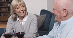 Senior couple laughing with wine in home for quality time, happy conversation and chat to relax together in retirement. Old man, elderly woman and smile with glass, alcohol and drink on sofa for love