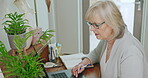 Writer, video call and senior woman online meeting doing remote work or planning retirement, schedule and writing. Idea, story and elderly person or worker journal in a notebook, story or novel book