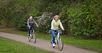 Health, senior couple and riding bicycle for exercise, fitness and wellness being healthy together in nature. Retirement, man and woman enjoy bike ride in a park or garden