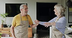 Senior couple, dance in kitchen and smile with love while making breakfast in their home. Happy old man, dancing with smiling elderly woman and fun in retirement together while cooking