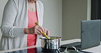 Cooking, senior woman and breakfast food in the kitchen of a house using a laptop online. Elderly person preparing a lunch on the stove at home