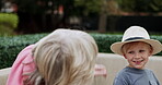 Senior woman and grandson bonding together in a garden with conversation and care. Love, putting on a hat and grandmother relax with family child