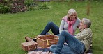 Couple, love in a garden on a picnic for a romantic holiday or vacation in spring. Happy senior man and woman bonding and relax in retirement