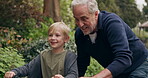 Grandfather teaching young boy to ride bicycle in garden, park and outdoor. Senior man helping happy kid with cycling on bike for fun, support and skill in nature
